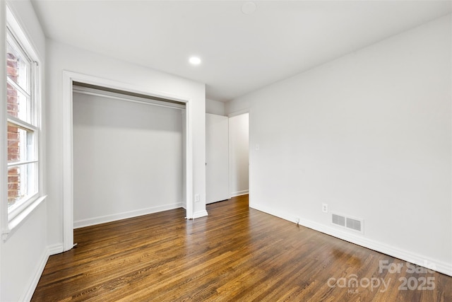 unfurnished bedroom with baseboards, visible vents, wood finished floors, a closet, and recessed lighting