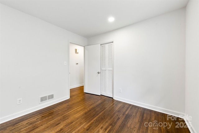 unfurnished bedroom featuring a closet, wood finished floors, visible vents, and baseboards