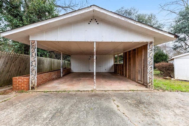 view of vehicle parking with fence and an attached carport