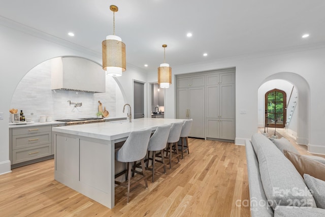 5124 Lansing Dr, Charlotte, NC 28270 - kitchen with gray cabinets, arched walkways, backsplash, crown molding, and a large island