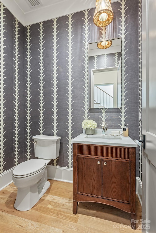 5124 Lansing Dr, Charlotte, NC 28270 - bathroom featuring wallpapered walls, wood finished floors, vanity, toilet, and baseboards