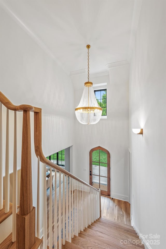 5124 Lansing Dr, Charlotte, NC 28270 - stairs featuring plenty of natural light, arched walkways, crown molding, wood finished floors, and a chandelier