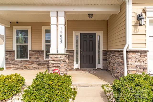 property entrance with covered porch and stone siding