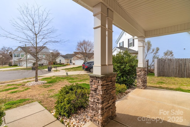 view of patio / terrace featuring a residential view, a porch, and fence