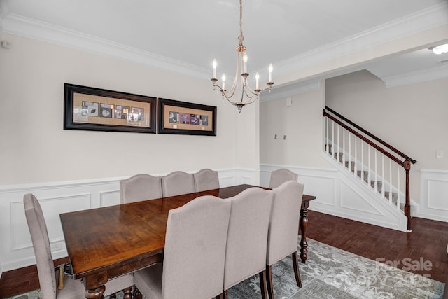 dining space featuring a notable chandelier, ornamental molding, wood finished floors, stairway, and wainscoting