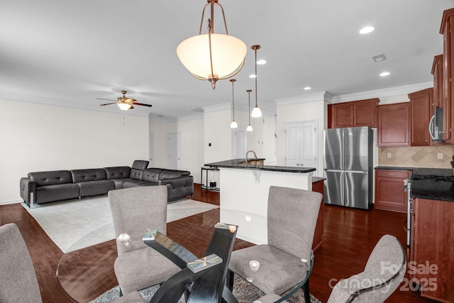 dining space featuring dark wood-style floors, visible vents, crown molding, and ceiling fan