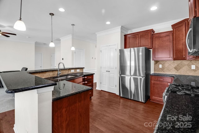 kitchen with a ceiling fan, a sink, stainless steel appliances, a large island with sink, and dark wood-style flooring