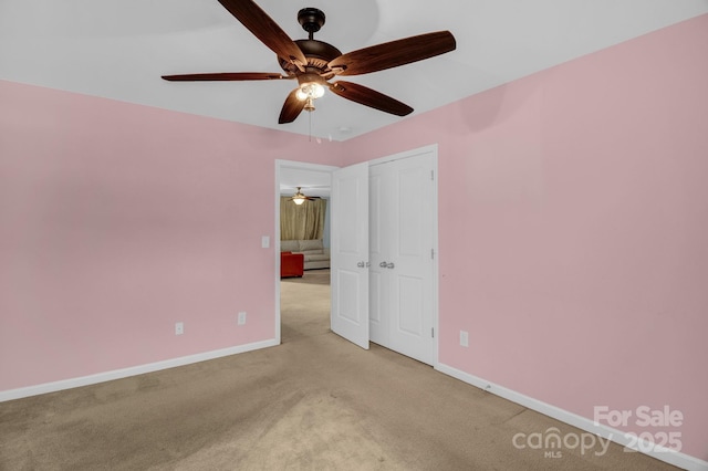 unfurnished room with baseboards, light carpet, and a ceiling fan