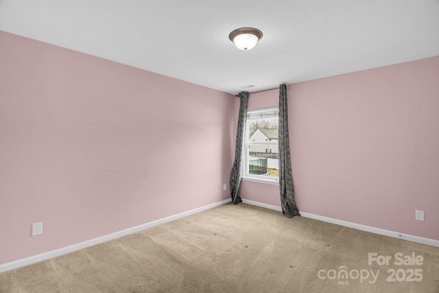 unfurnished room featuring baseboards and carpet floors