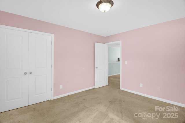 unfurnished bedroom featuring a closet, baseboards, and carpet