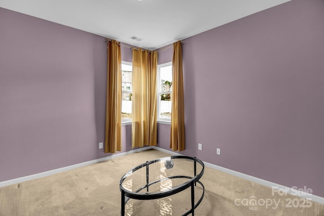 spare room with baseboards, light carpet, and visible vents