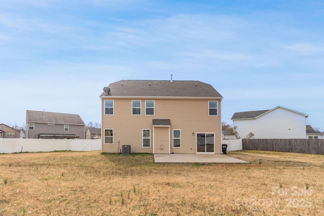 rear view of house with a patio, a yard, and a fenced backyard