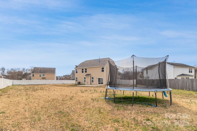 view of yard with a trampoline and a fenced backyard