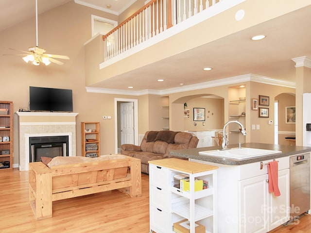 living area featuring a ceiling fan, crown molding, light wood-type flooring, a fireplace, and recessed lighting