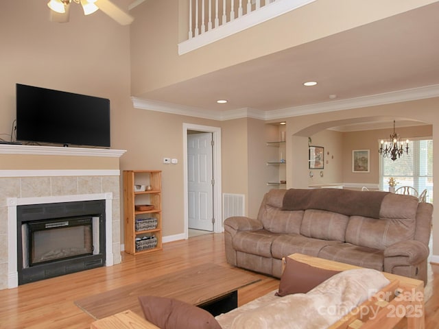 living area featuring built in shelves, crown molding, and wood finished floors