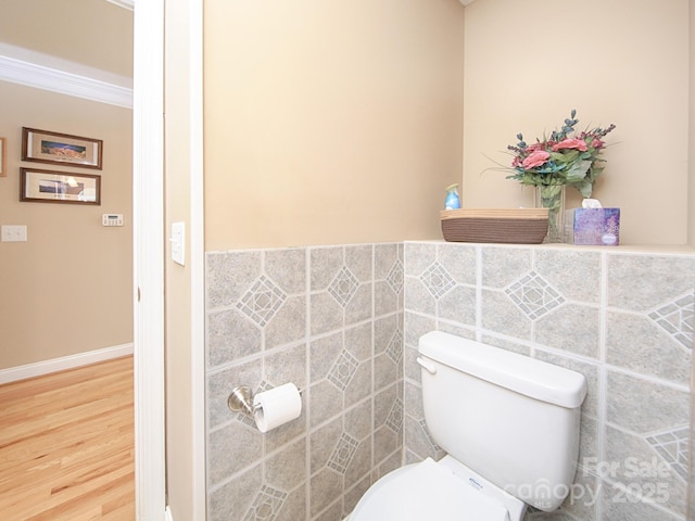 bathroom featuring crown molding, tile walls, toilet, and wood finished floors