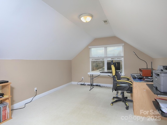 carpeted home office with lofted ceiling, visible vents, and baseboards