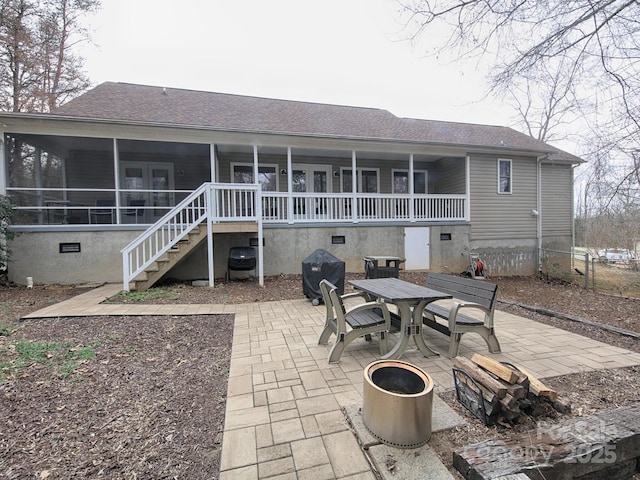 rear view of house with outdoor dining area, a shingled roof, crawl space, stairway, and a patio area