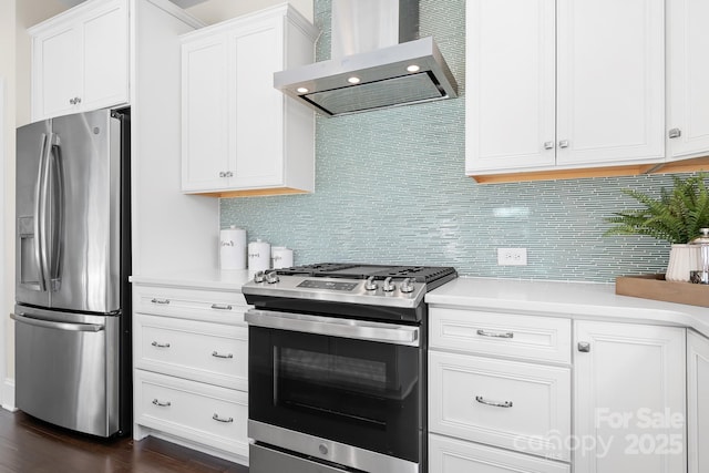 kitchen featuring light countertops, wall chimney range hood, backsplash, and appliances with stainless steel finishes