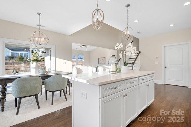 kitchen featuring visible vents, decorative light fixtures, light countertops, lofted ceiling, and dark wood-style flooring