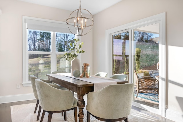 dining room with wood finished floors, baseboards, and a chandelier