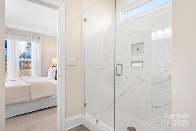 ensuite bathroom featuring a shower stall, ensuite bathroom, and baseboards