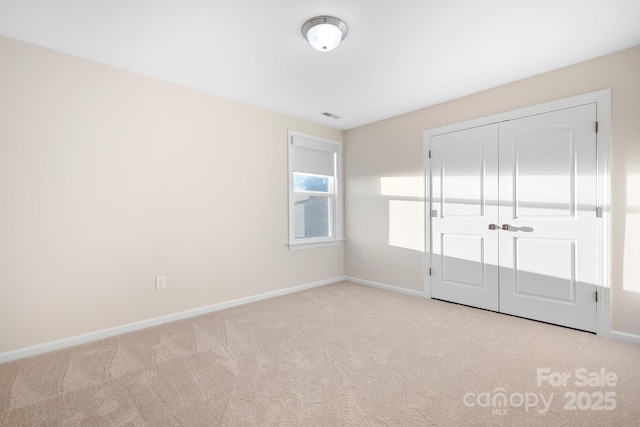 unfurnished bedroom with a closet, baseboards, visible vents, and carpet floors