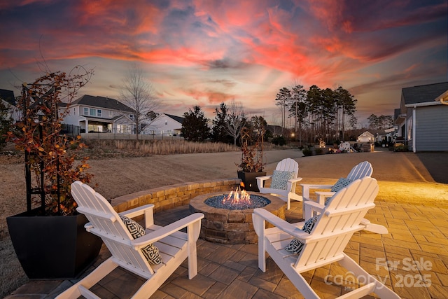 patio terrace at dusk with an outdoor fire pit and fence