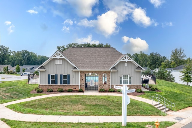 craftsman inspired home with brick siding, board and batten siding, a shingled roof, and a front lawn