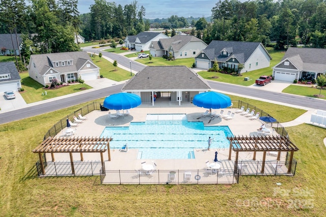 pool with fence, a residential view, a yard, a pergola, and a patio