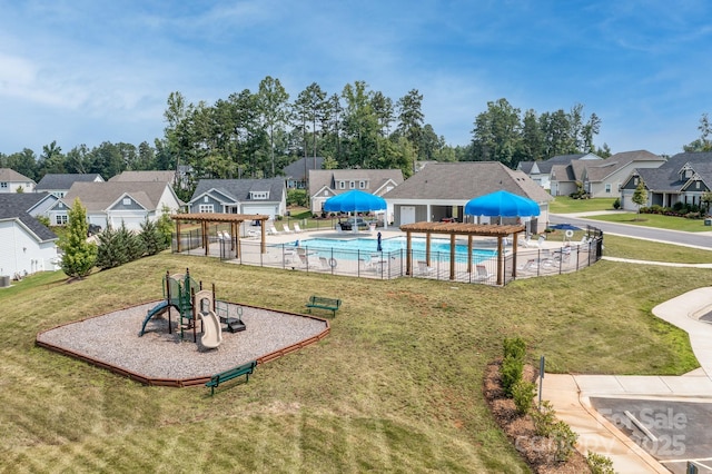 community playground with a residential view, a lawn, and a community pool