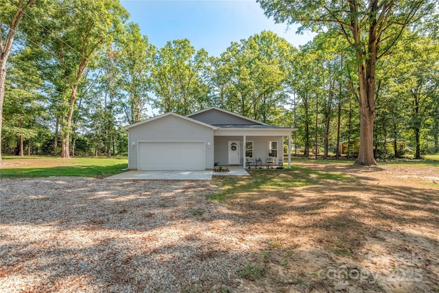 view of front of home featuring a porch, a front lawn, driveway, and a garage