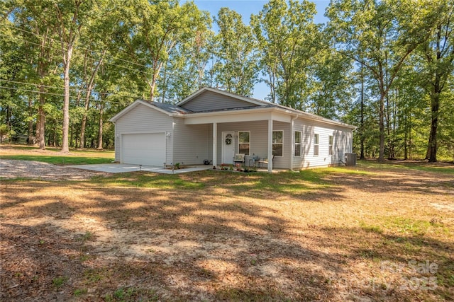 view of front of house with a garage, concrete driveway, central air condition unit, a porch, and a front yard