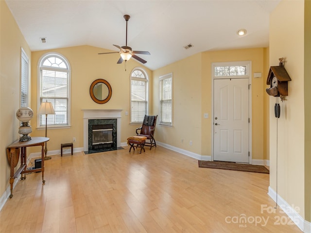 entryway with light wood-style flooring, visible vents, a wealth of natural light, and a high end fireplace