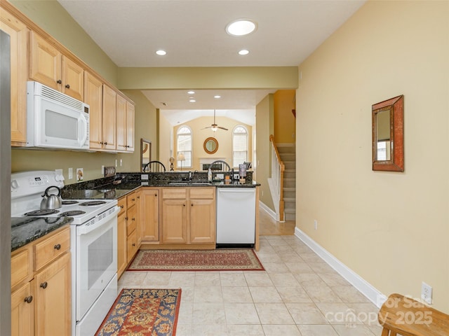 kitchen with ceiling fan, dark stone countertops, white appliances, a peninsula, and baseboards