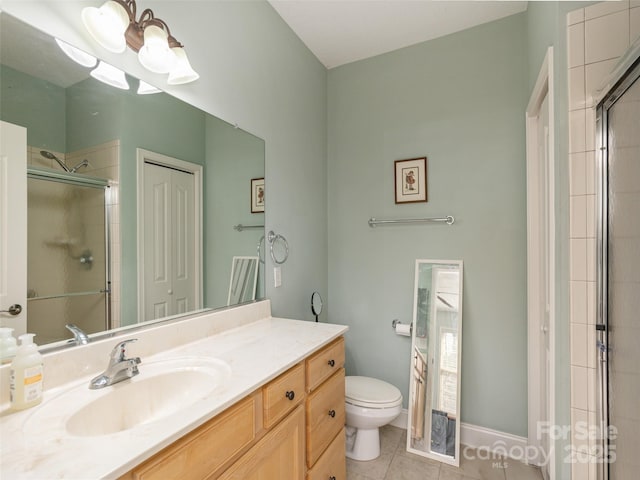 bathroom featuring a stall shower, baseboards, toilet, tile patterned floors, and vanity