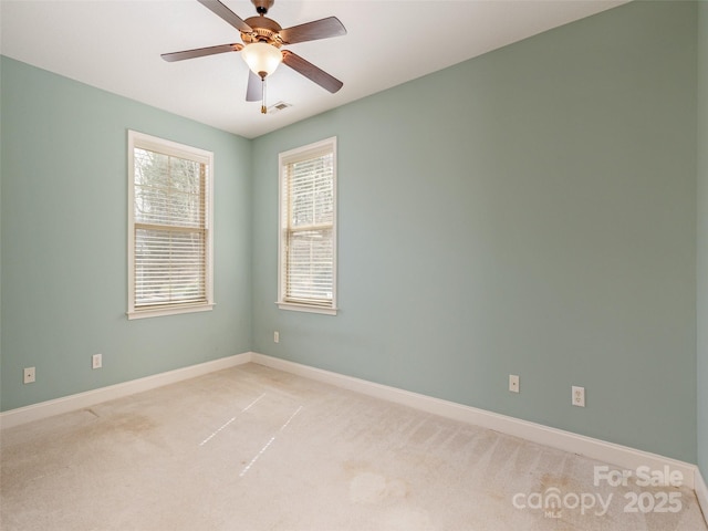 unfurnished room with light colored carpet, ceiling fan, and baseboards