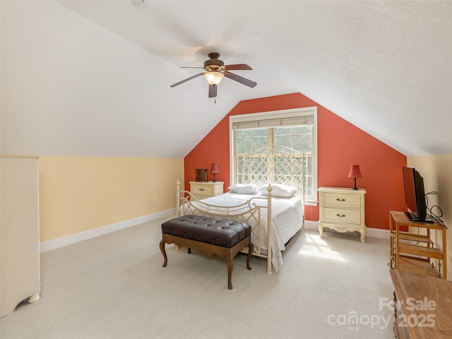 bedroom featuring baseboards, ceiling fan, vaulted ceiling, a textured ceiling, and carpet flooring