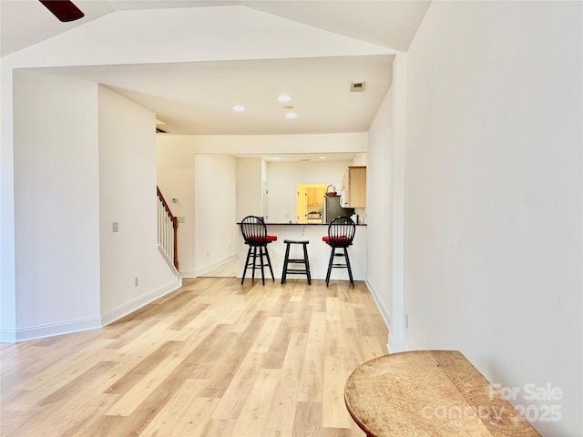 interior space with vaulted ceiling, stairs, light wood-type flooring, baseboards, and recessed lighting