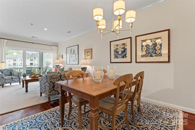 dining space featuring a notable chandelier, crown molding, baseboards, and dark wood finished floors