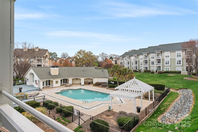 community pool featuring a fenced backyard, a lawn, a pergola, and a patio area
