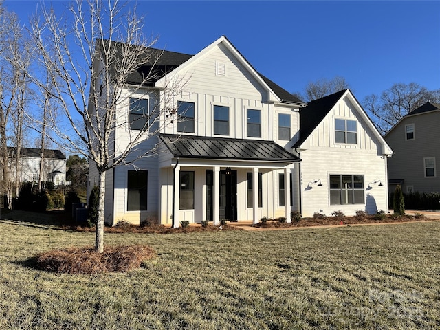 modern farmhouse style home featuring covered porch, board and batten siding, a front yard, a standing seam roof, and metal roof