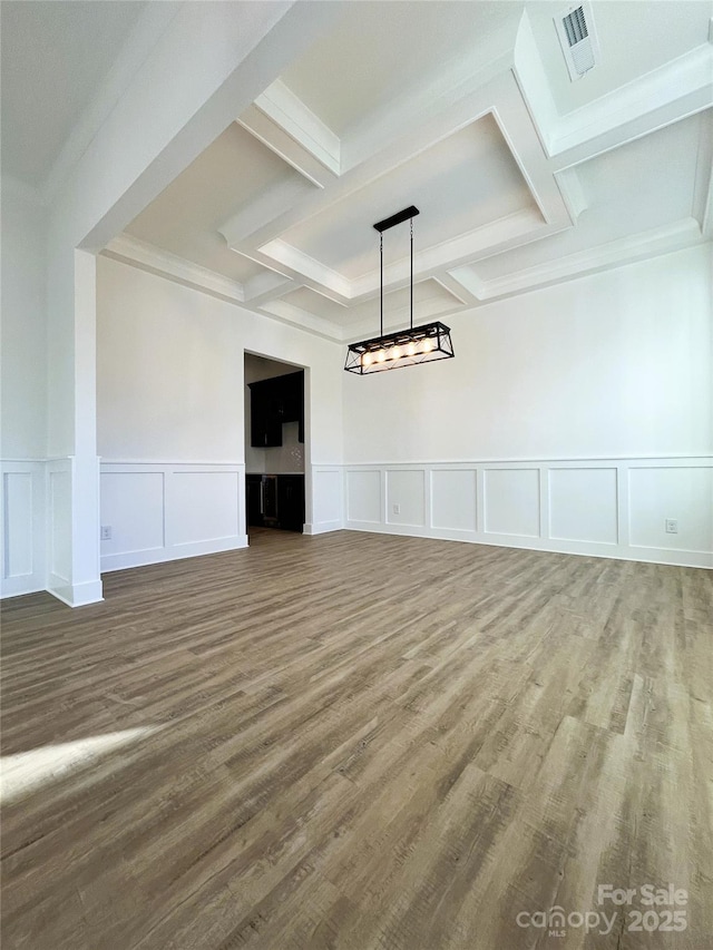 unfurnished room featuring beam ceiling, visible vents, coffered ceiling, and wood finished floors