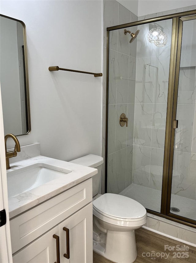 bathroom featuring a stall shower, vanity, and toilet