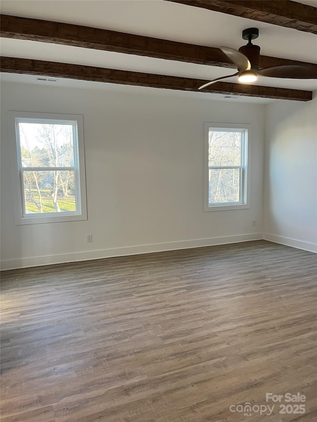 unfurnished room featuring a ceiling fan, wood finished floors, beam ceiling, and baseboards