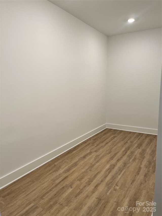 unfurnished room with dark wood-type flooring, recessed lighting, and baseboards