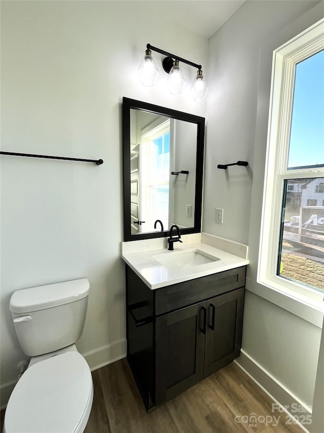 half bathroom featuring a wealth of natural light and wood finished floors