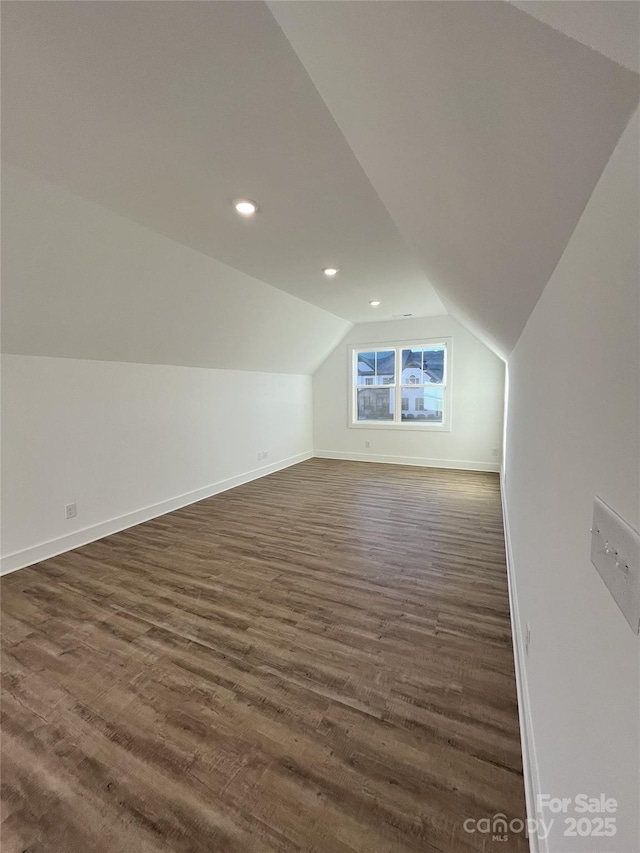 additional living space featuring recessed lighting, vaulted ceiling, dark wood finished floors, and baseboards