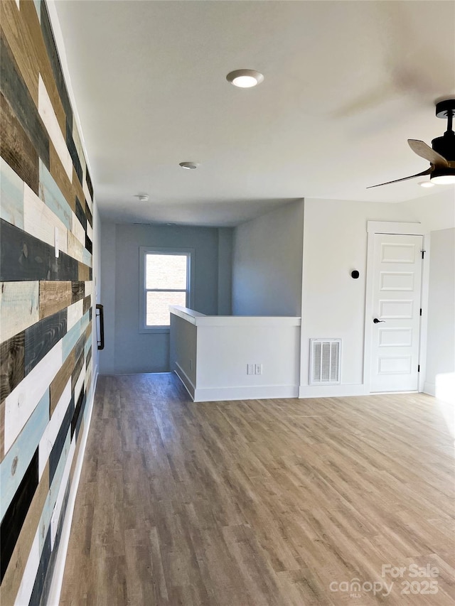 spare room featuring visible vents, ceiling fan, and wood finished floors