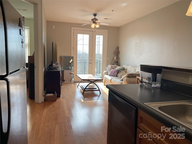 living room featuring french doors, light wood-type flooring, and a ceiling fan